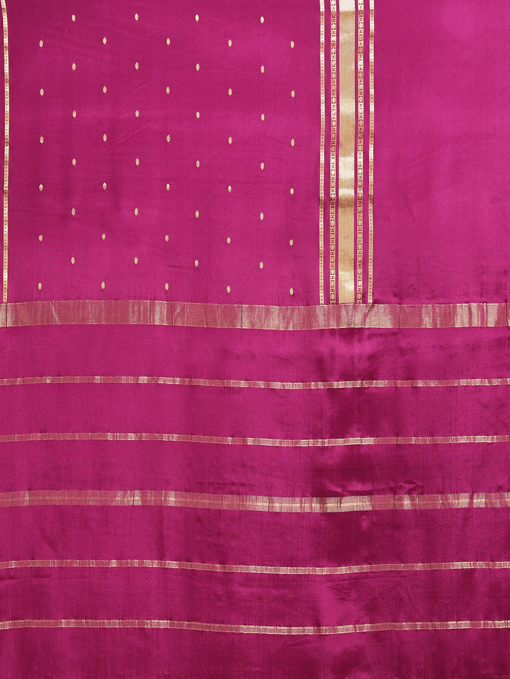 Close up of rani pink body with scattered oval gold zari buttas and horizontal stripe pallu bands