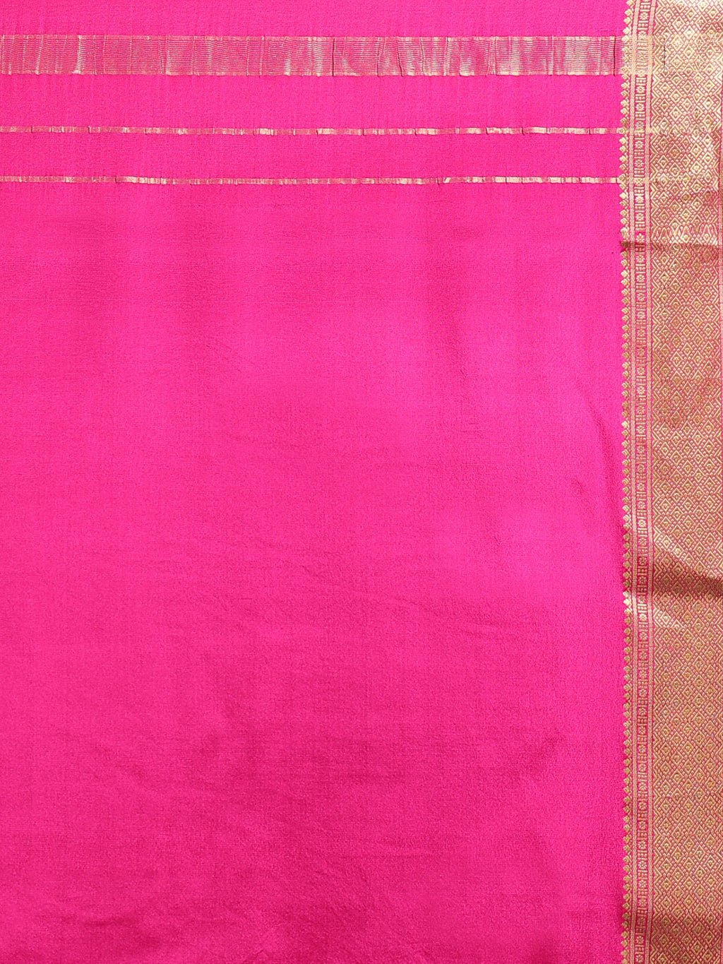 Close up of fuchsia silk with wide antique gold zari geometric temple border and horizontal stripe pallu