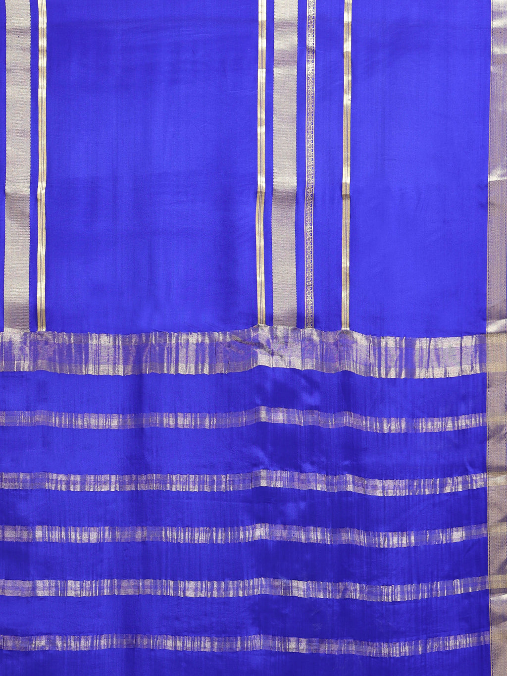 Close up of royal blue body with sparse vertical silver zari stripes and wide horizontal silver zari stripe pallu bands