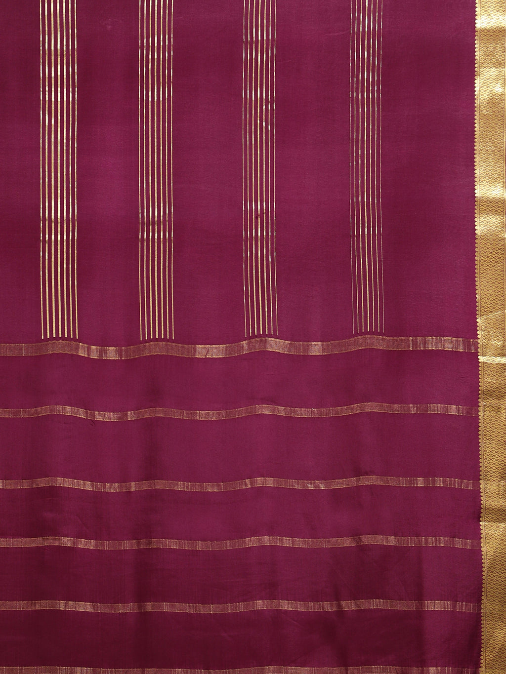 Close up of deep burgundy body with clusters of fine vertical gold zari stripe panels and horizontal stripe pallu bands