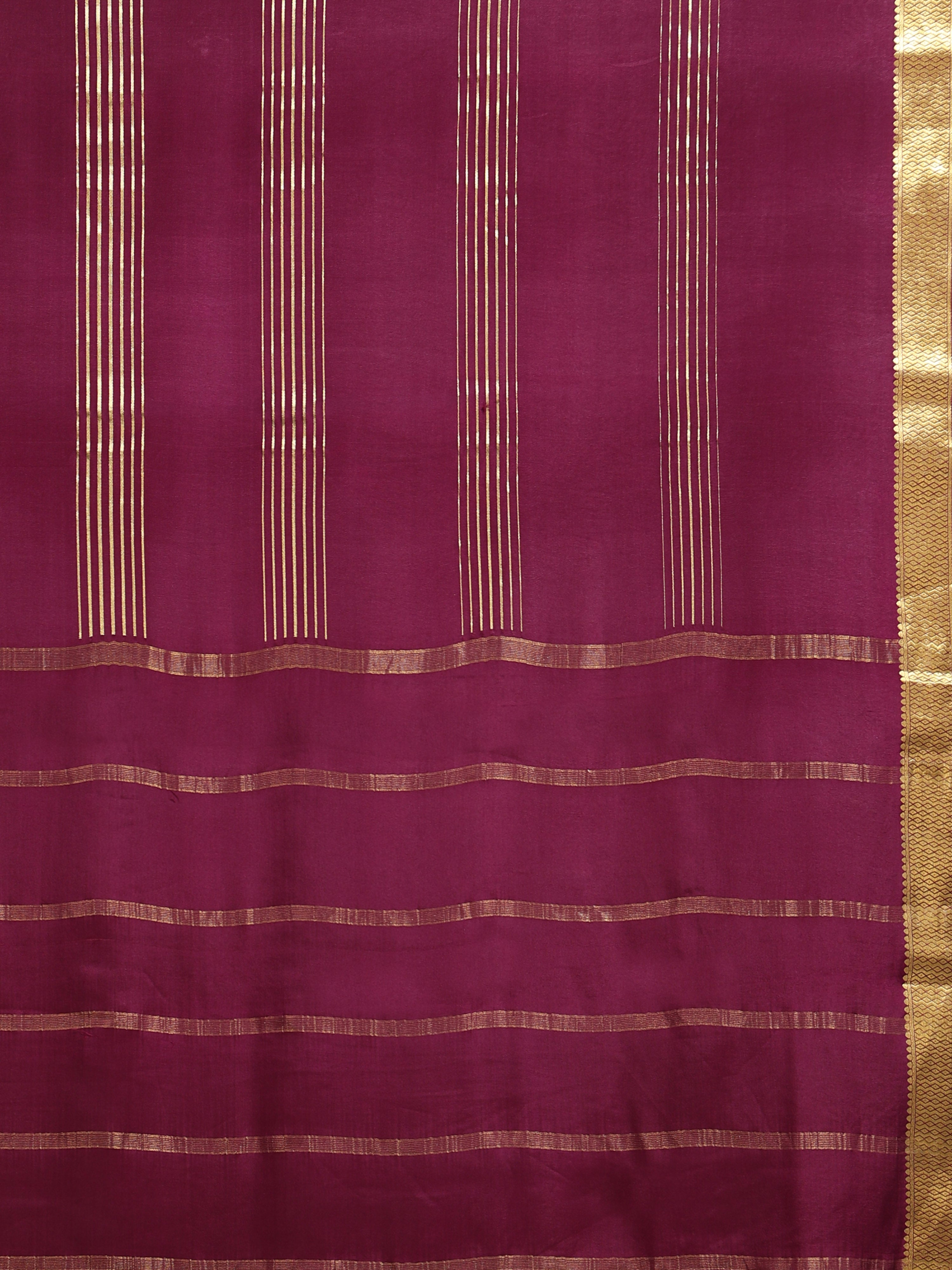 Close up of deep burgundy body with clusters of fine vertical gold zari stripe panels and horizontal stripe pallu bands