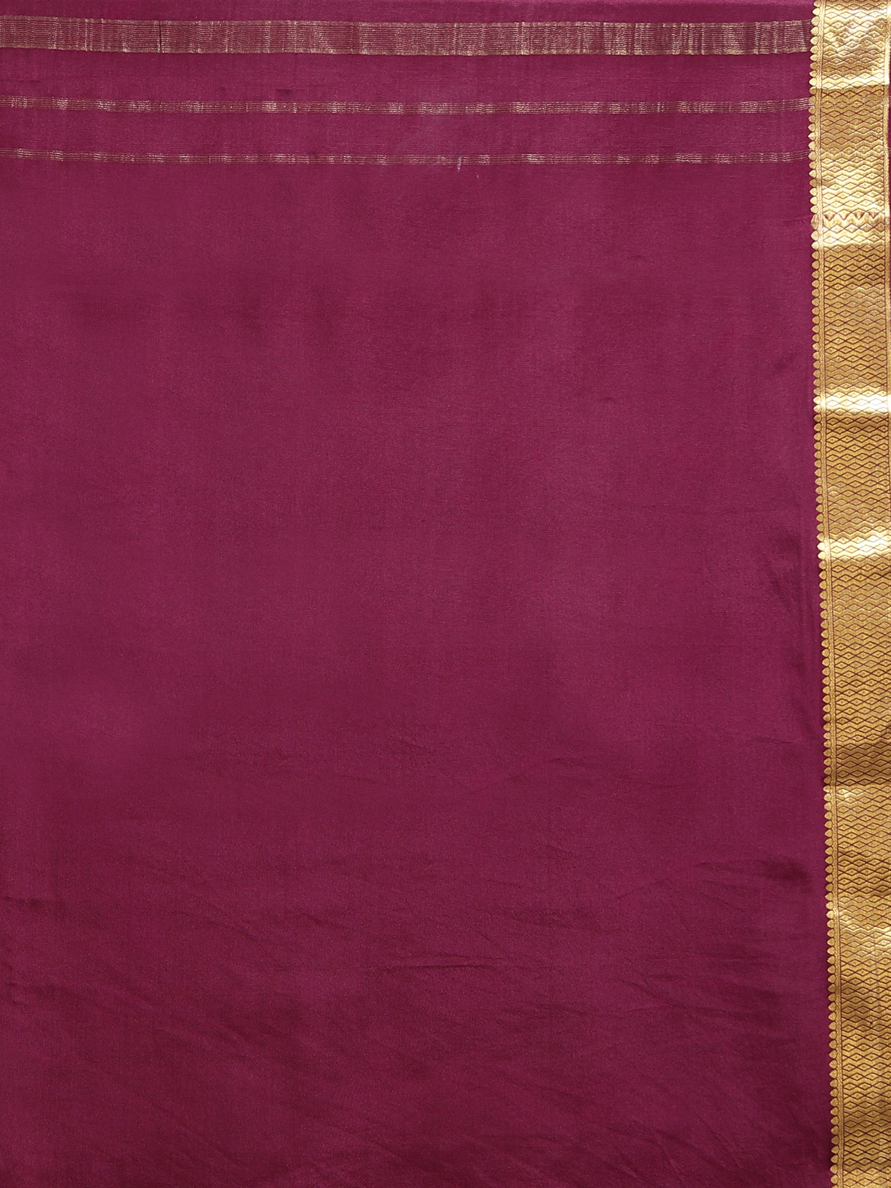 Close up of plain burgundy silk body with natural lustre and wide antique gold zari diamond chevron geometric border