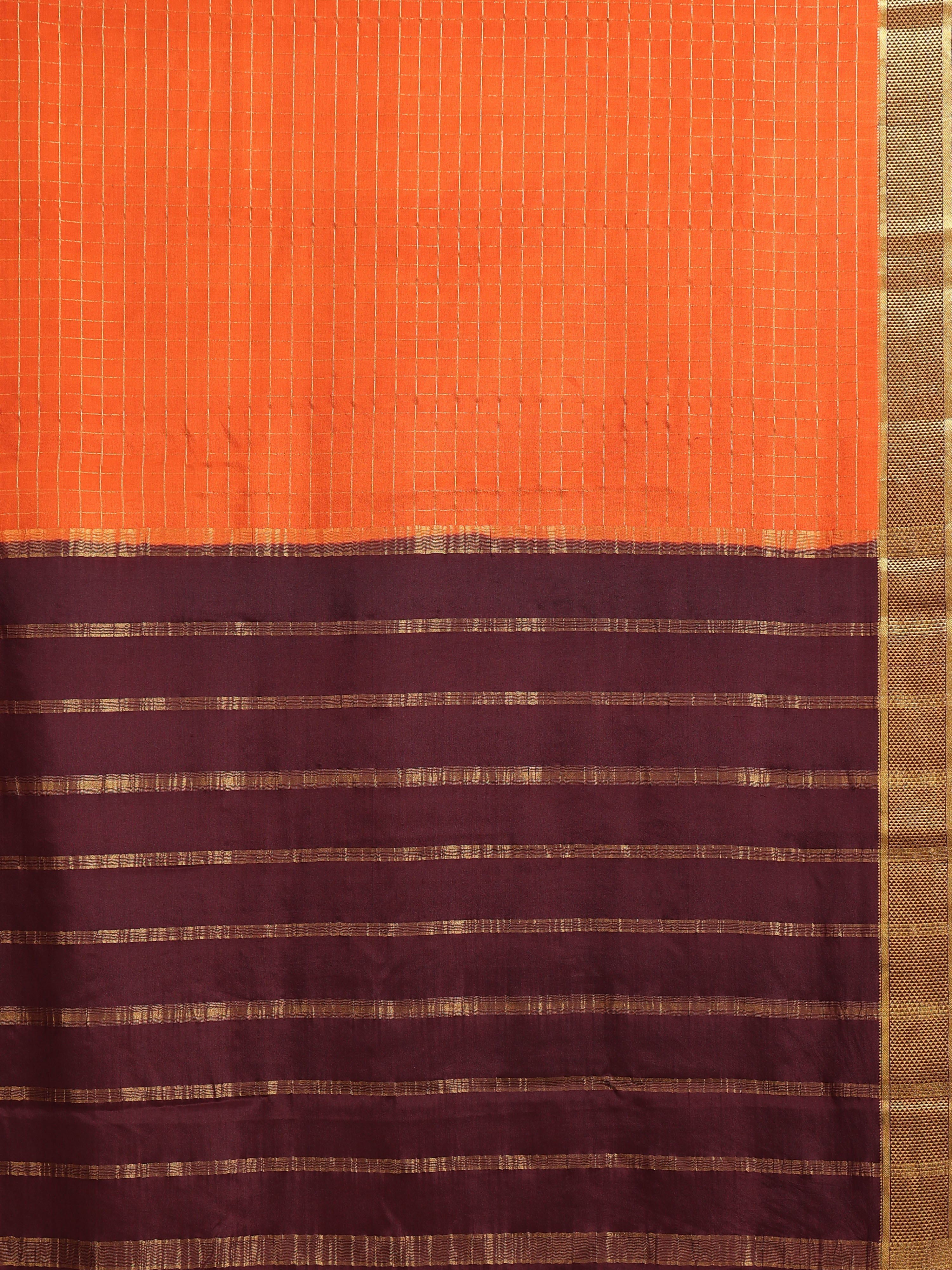 Close up of tangerine orange body with fine gold zari check grid and deep plum pallu with horizontal gold zari dash stripe bands