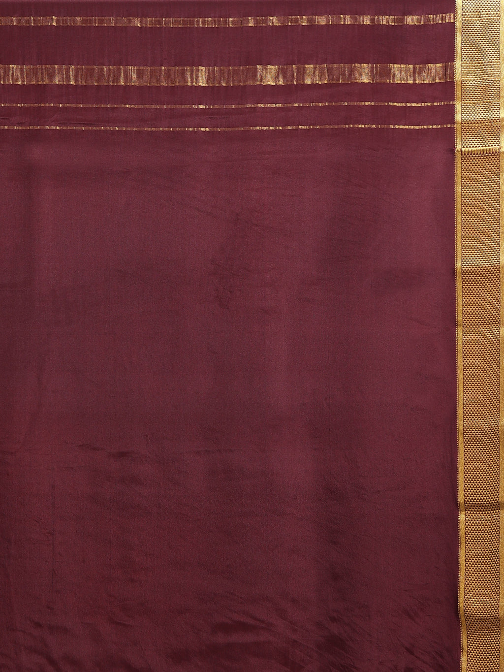Close up of plain deep plum silk blouse piece with narrow antique gold zari honeycomb border and horizontal gold zari stripe lines