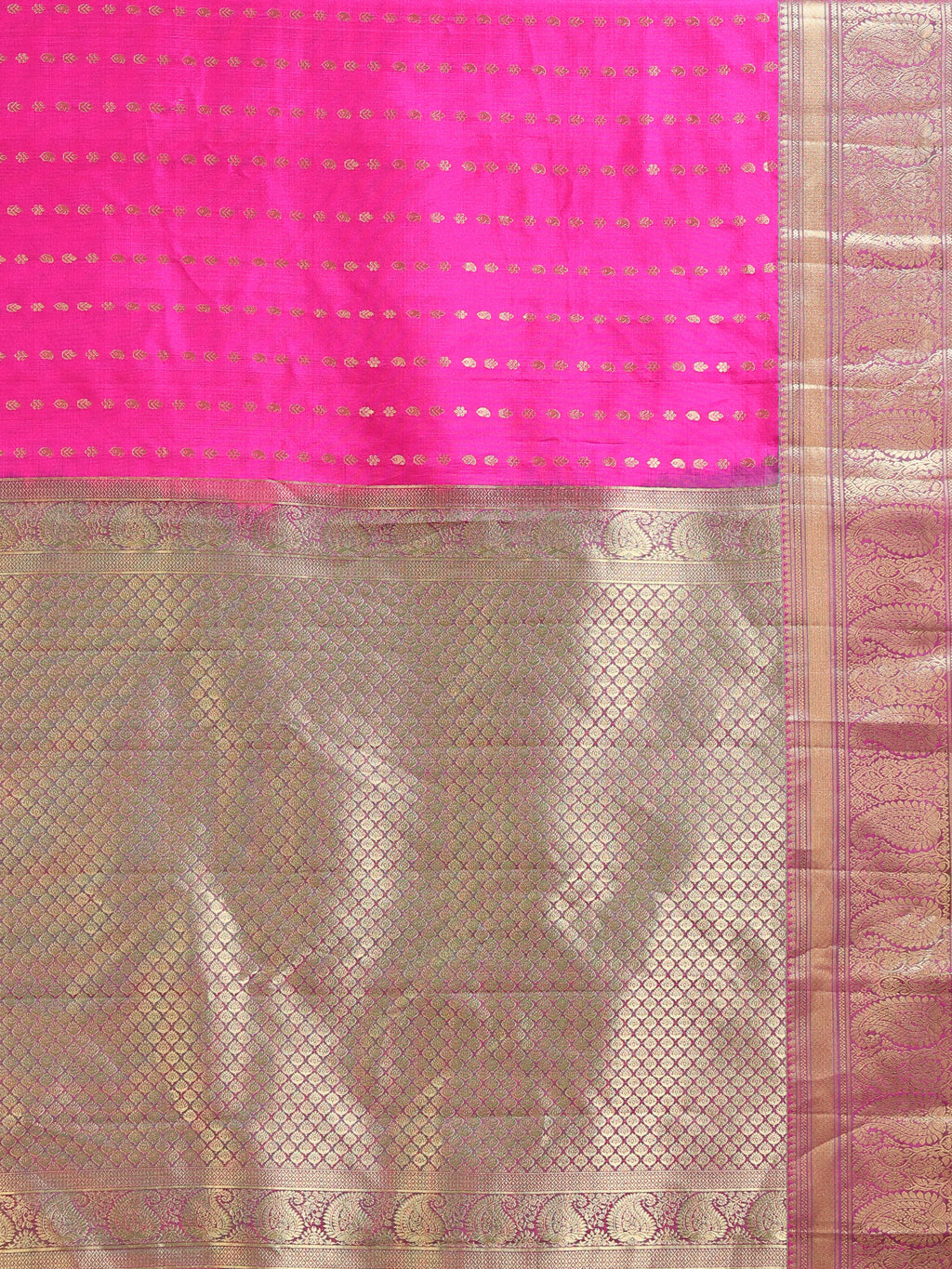 Close up of hot pink shot silk body with rows of gold zari oval diamond buttas and all-over antique gold jaal pallu