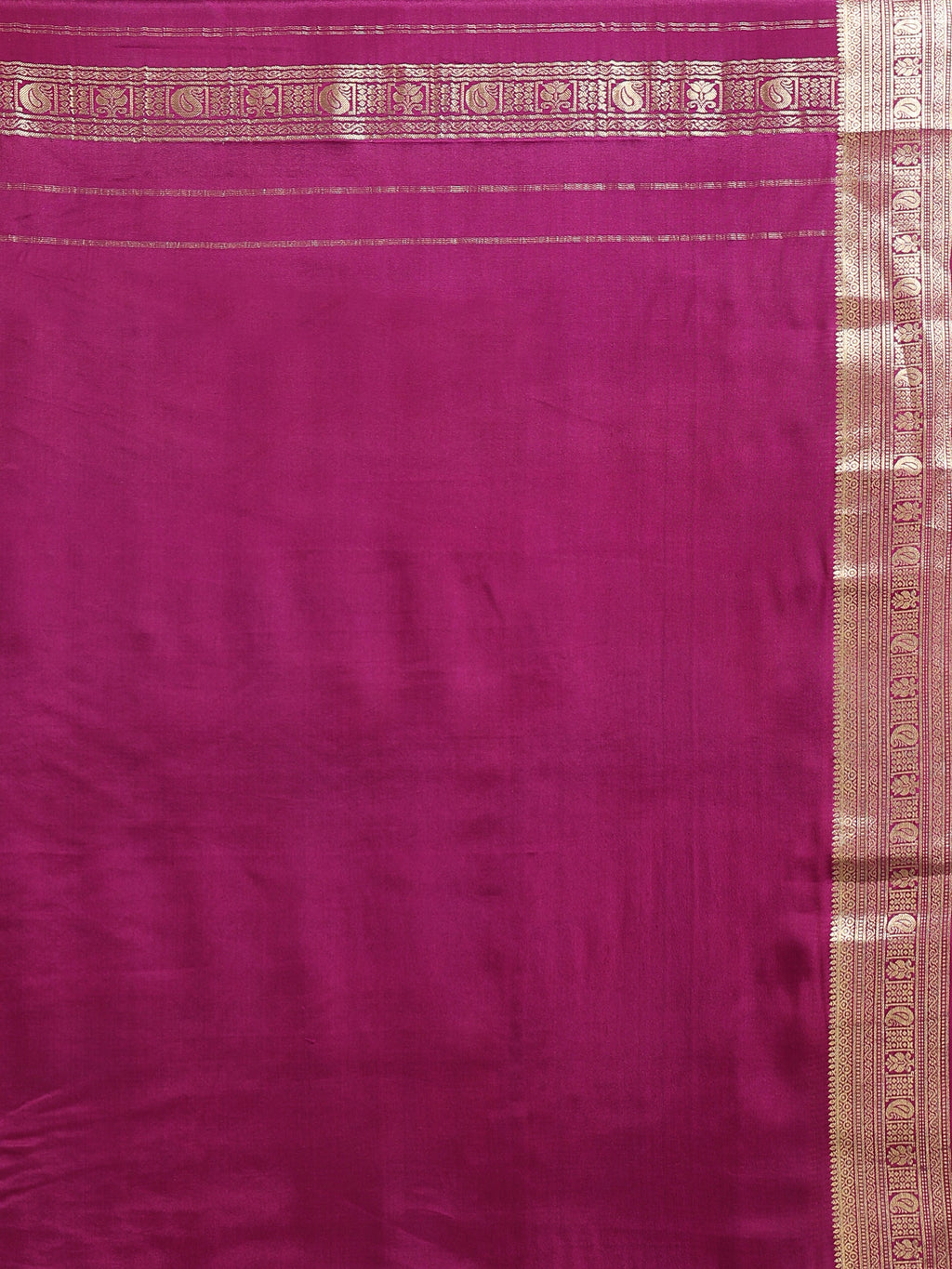 Close up of plain deep magenta silk blouse piece with narrow multi-band antique gold zari peacock paisley border