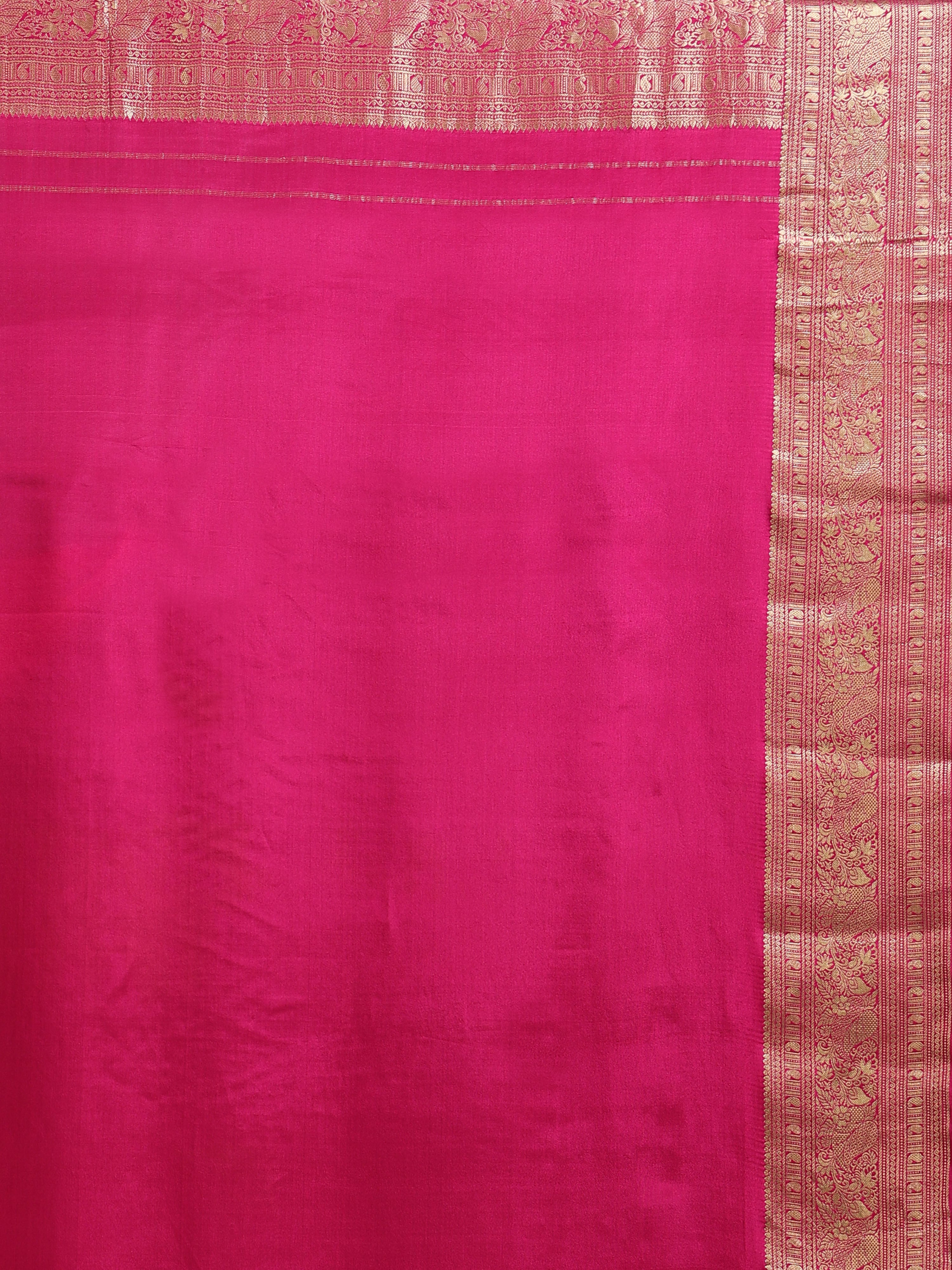 Close up of plain deep magenta silk blouse piece with wide multi-band antique gold zari floral scrollwork border