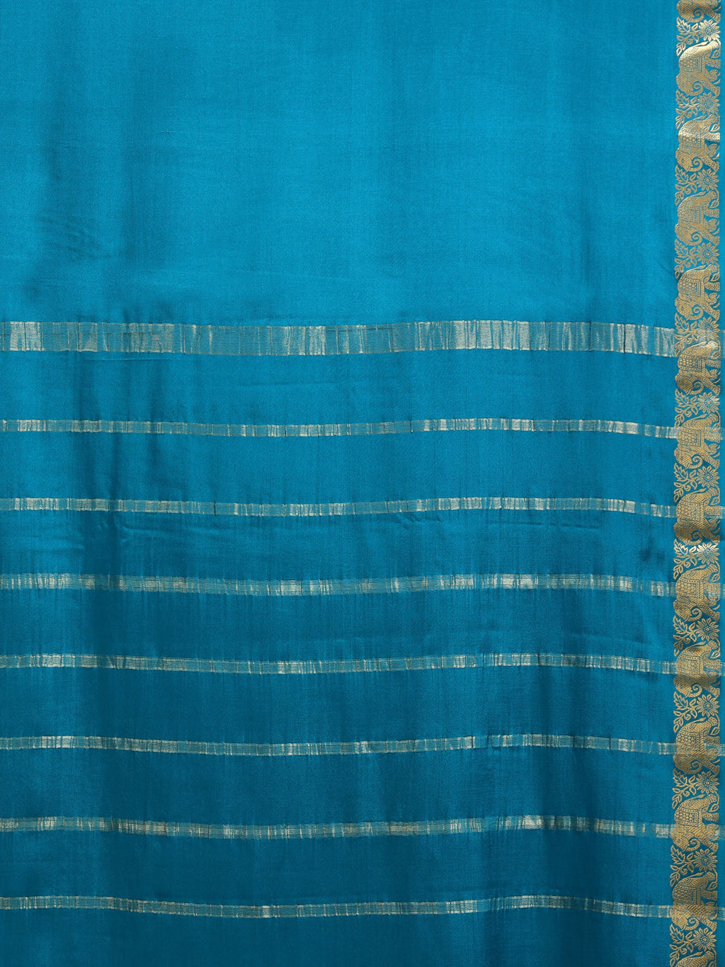 Close up of plain teal body with wide horizontal antique gold zari block stripe bands on pallu and narrow elephant motif border