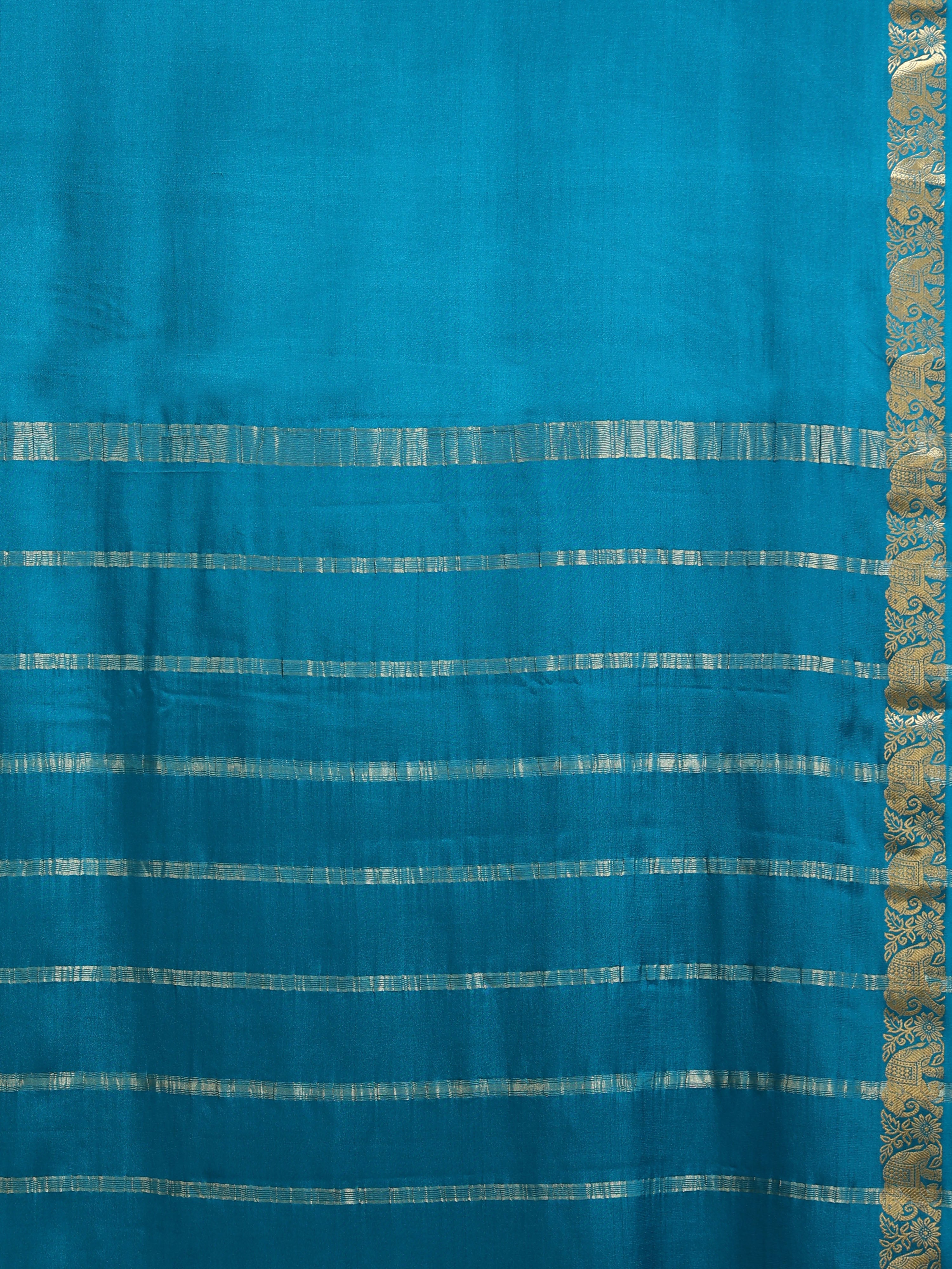 Close up of plain teal body with wide horizontal antique gold zari block stripe bands on pallu and narrow elephant motif border