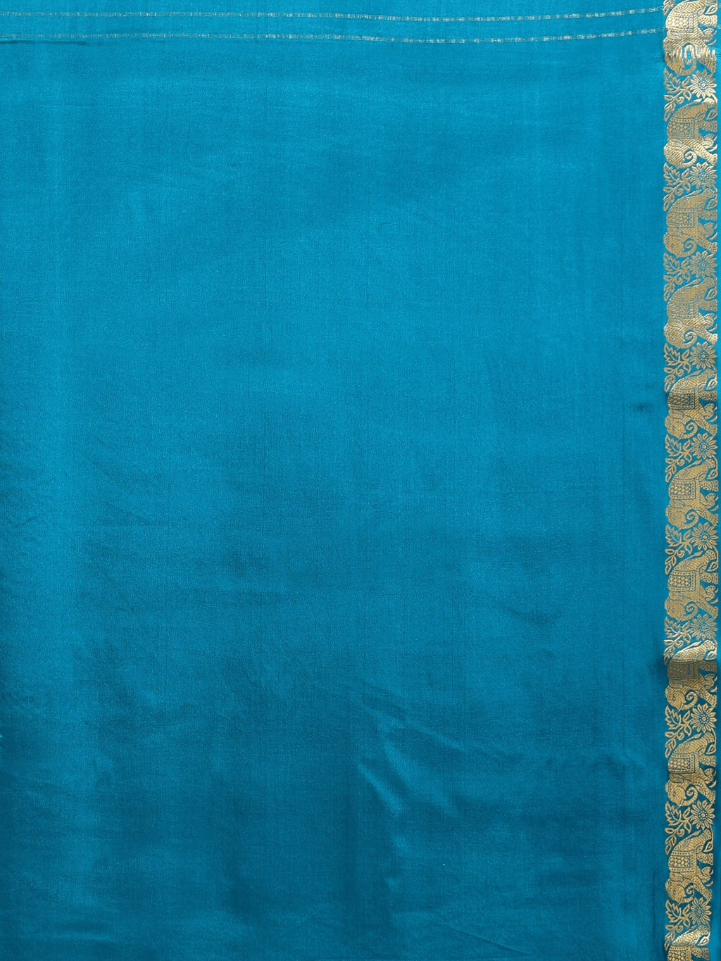 Close up of plain teal silk blouse piece with narrow antique gold bronze zari floral scrollwork and elephant animal motif border