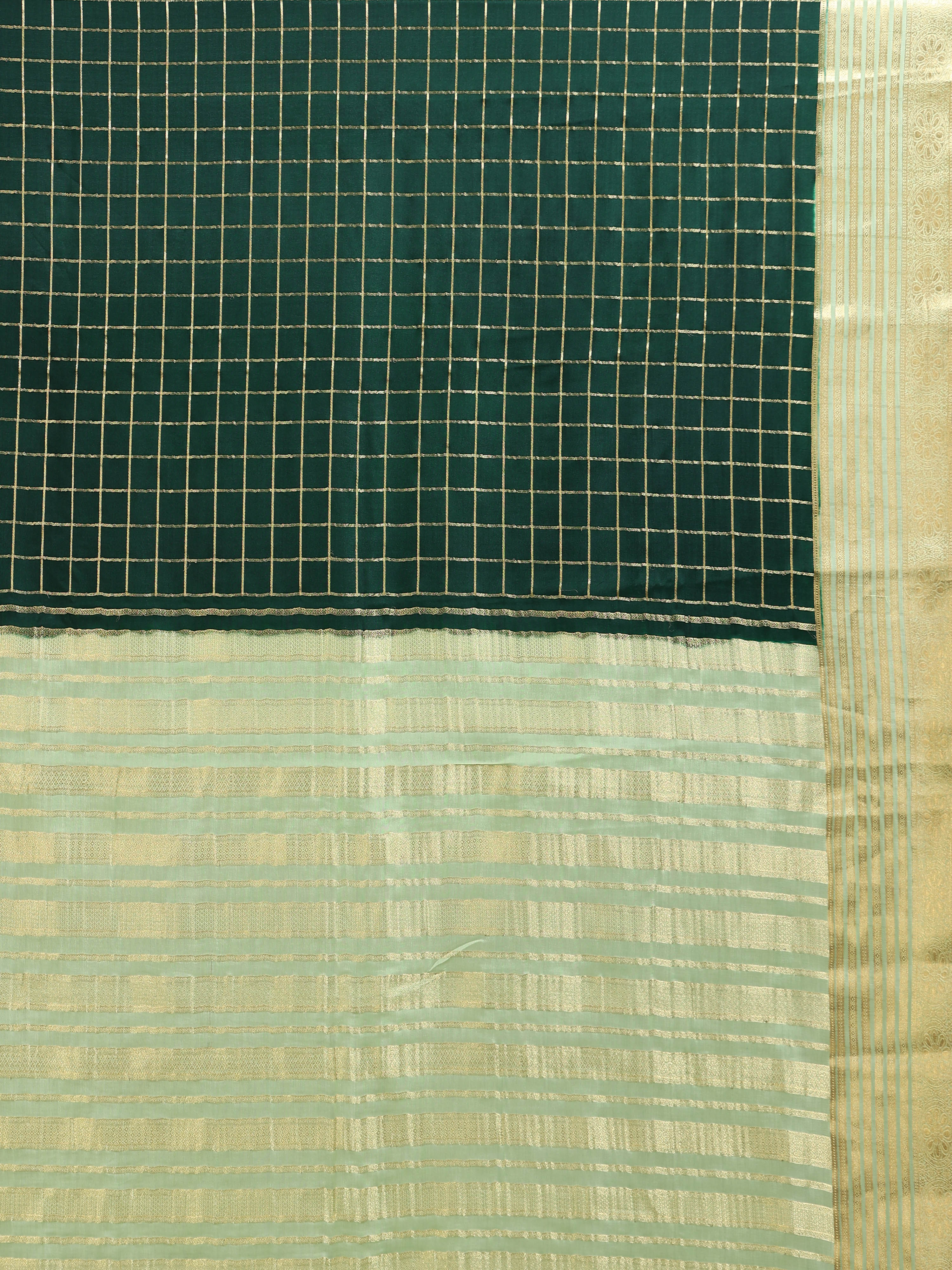 Close up of deep bottle green body with large two-tone gold silver zari check grid and soft mint pallu with dense horizontal gold zari stripe bands